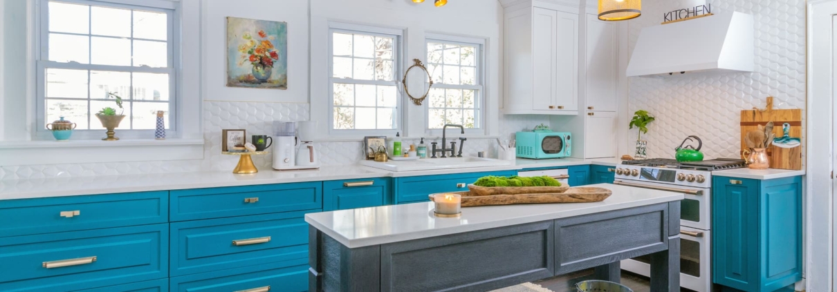 teal kitchen with gold lights and an island