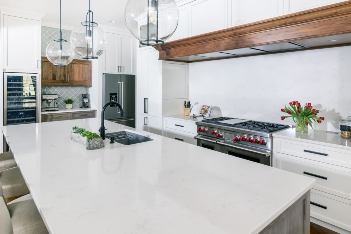 white kitchen with a large walnut hood