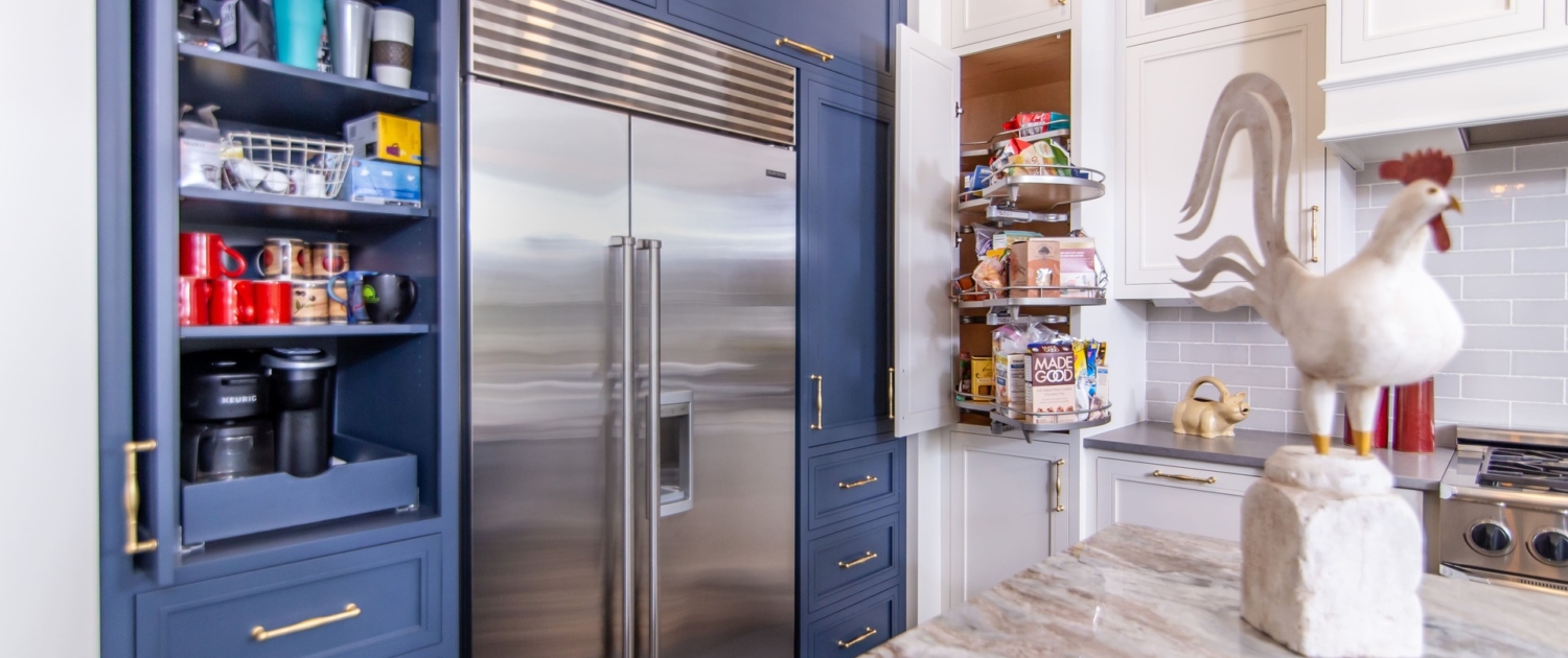 A kitchen with white and blue cabinetry and a beverage station