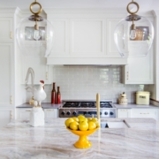 A kitchen with white and blue cabinetry and with glass front doors