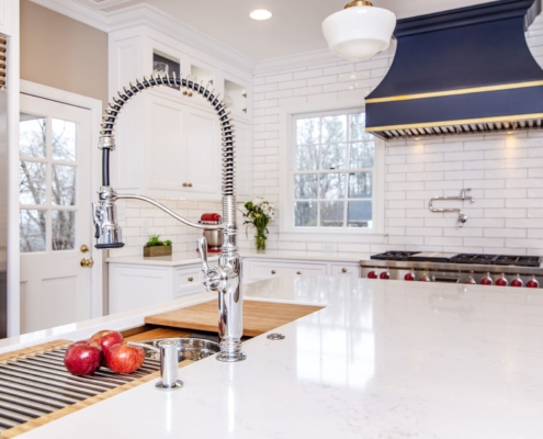 White kitchen cabinets with a large blue hood