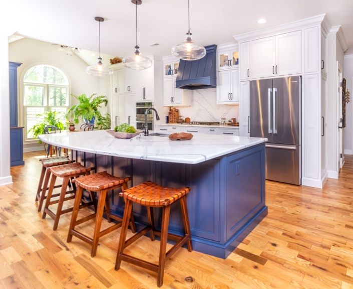 white kitchen with a blue island and barstools
