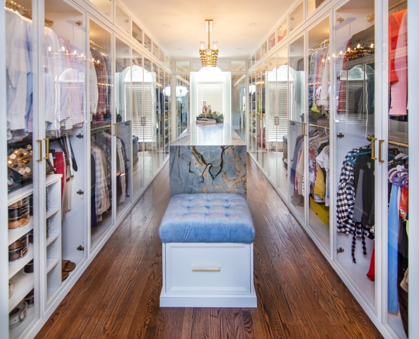 Custom closet with glass doors and an island