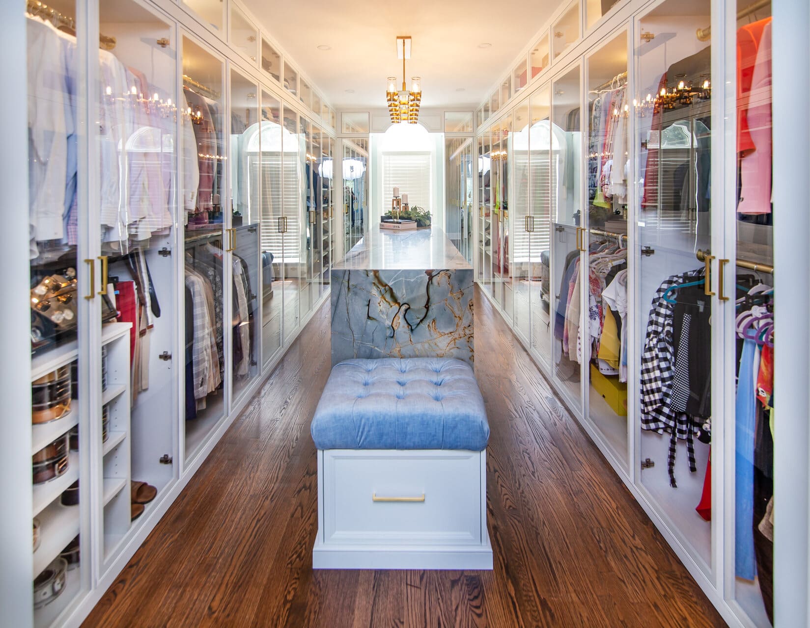 Custom closet with glass doors and an island