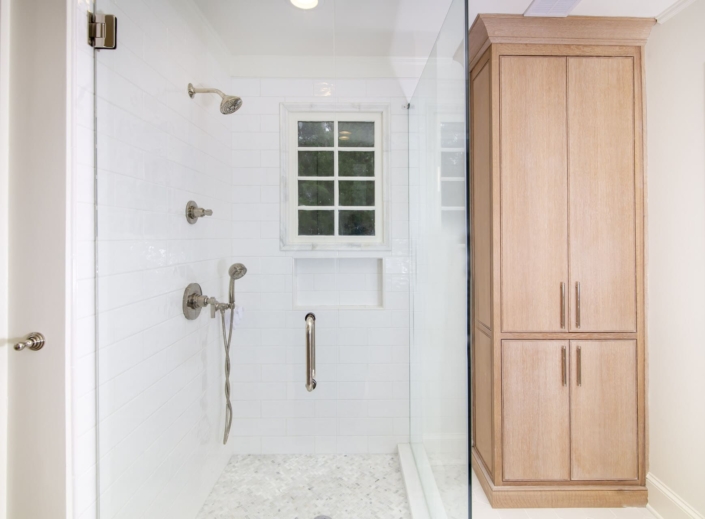 walk in shower and a linen cabinet