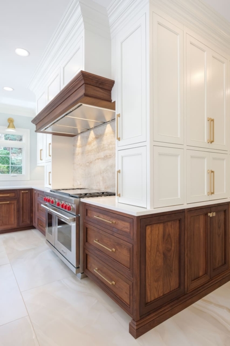 Brown and white kitchen cabinets and a hood