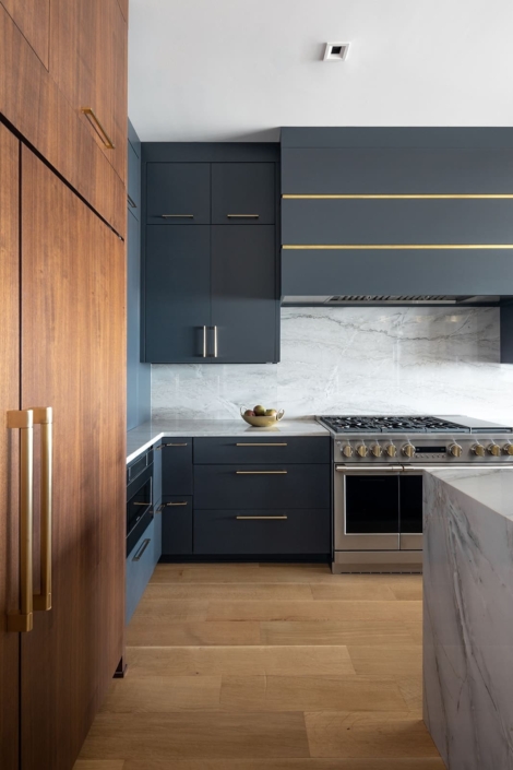 blue kitchen with a paneled fridge