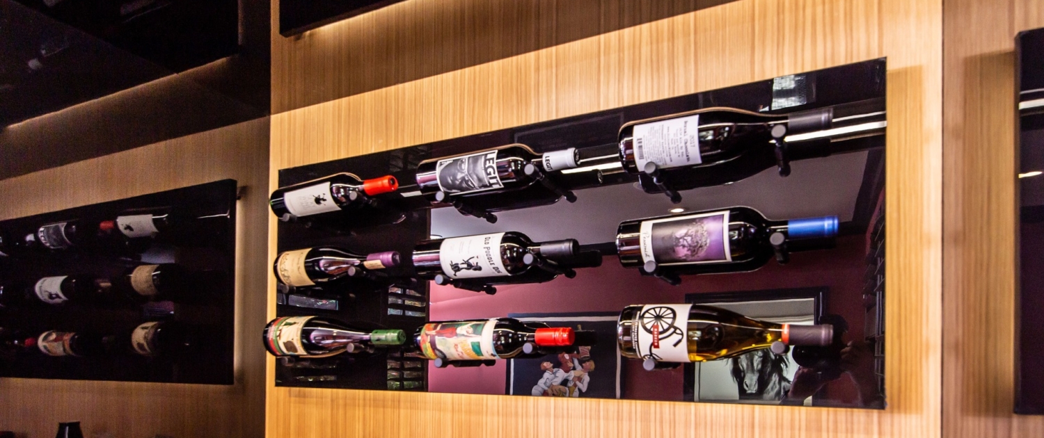 A custom wine bottle display beverage center with wine bottles hung all on it
