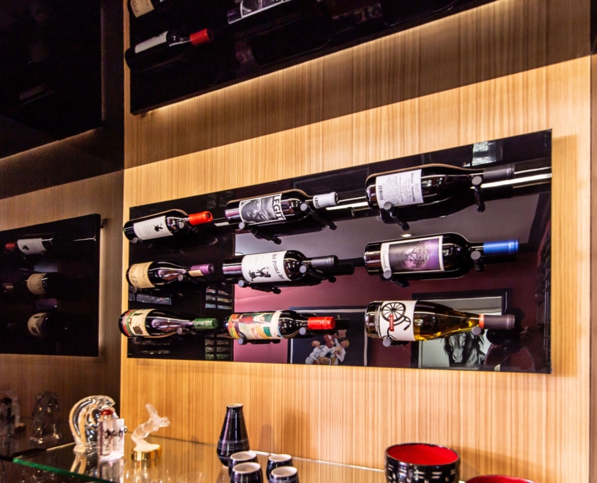 A custom wine bottle display beverage center with wine bottles hung all on it
