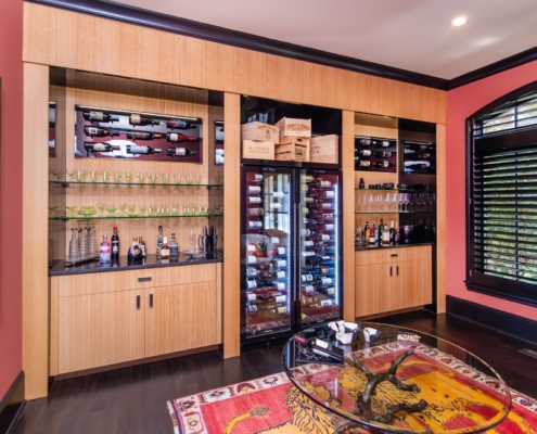 A custom wine room with oak cabinetry and with a built in wine cooler