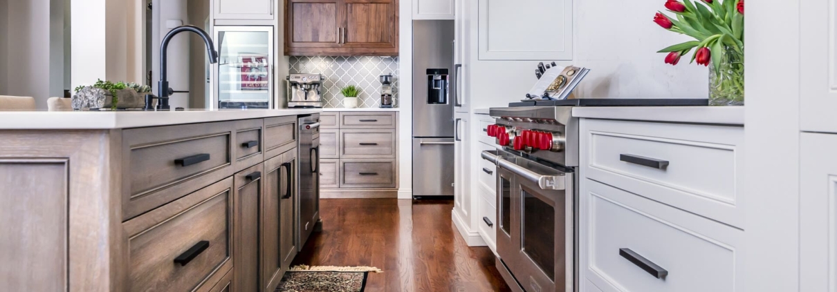 white kitchen and brown island with hardwood floors
