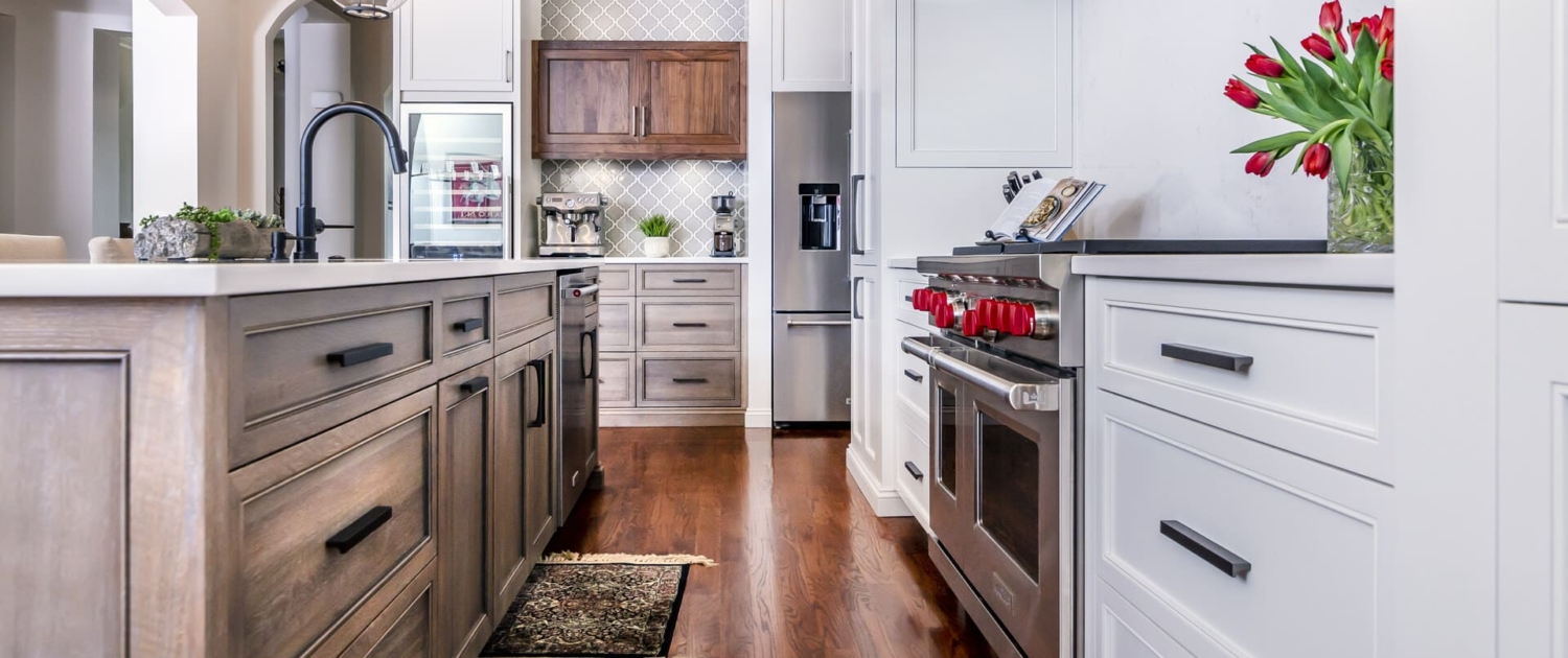 white kitchen and brown island with hardwood floors