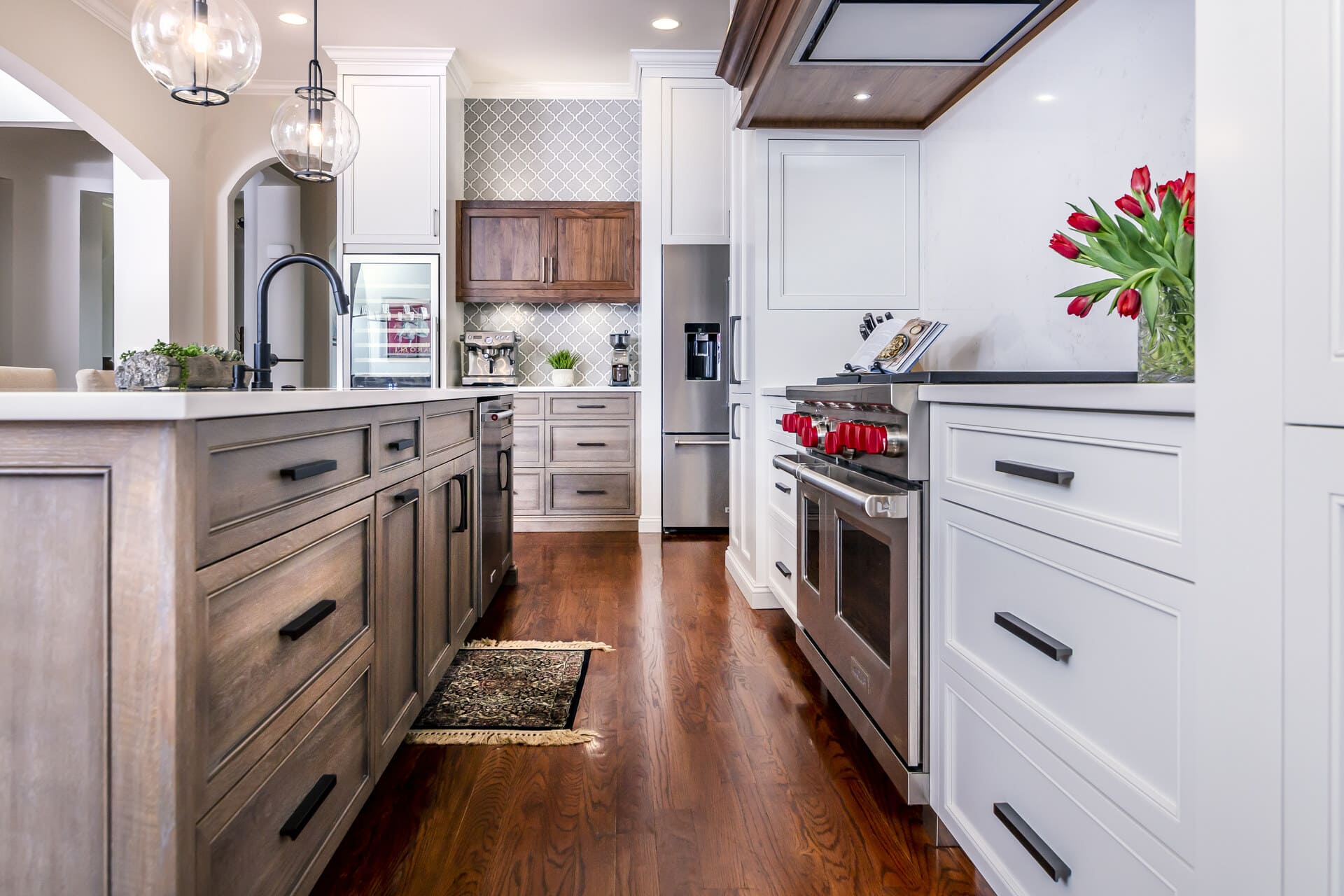 white kitchen and brown island with hardwood floors