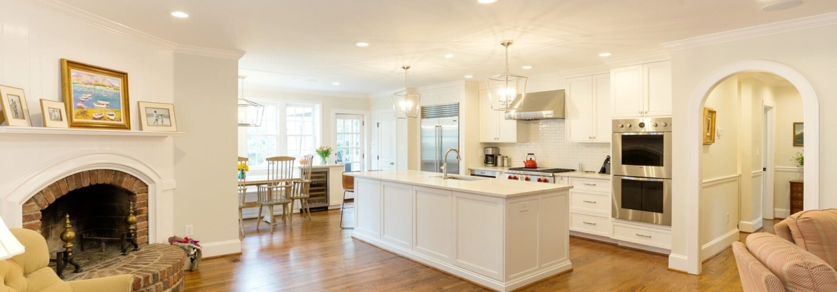 white kitchen and living room with a fireplace