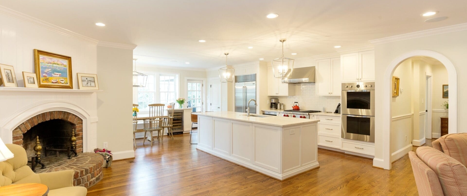 white kitchen and living room with a fireplace