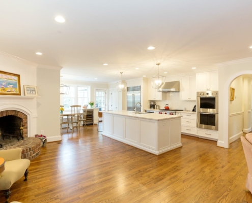 white kitchen and living room with a fireplace
