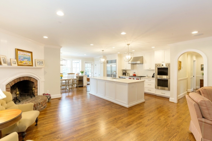 white kitchen and living room with a fireplace