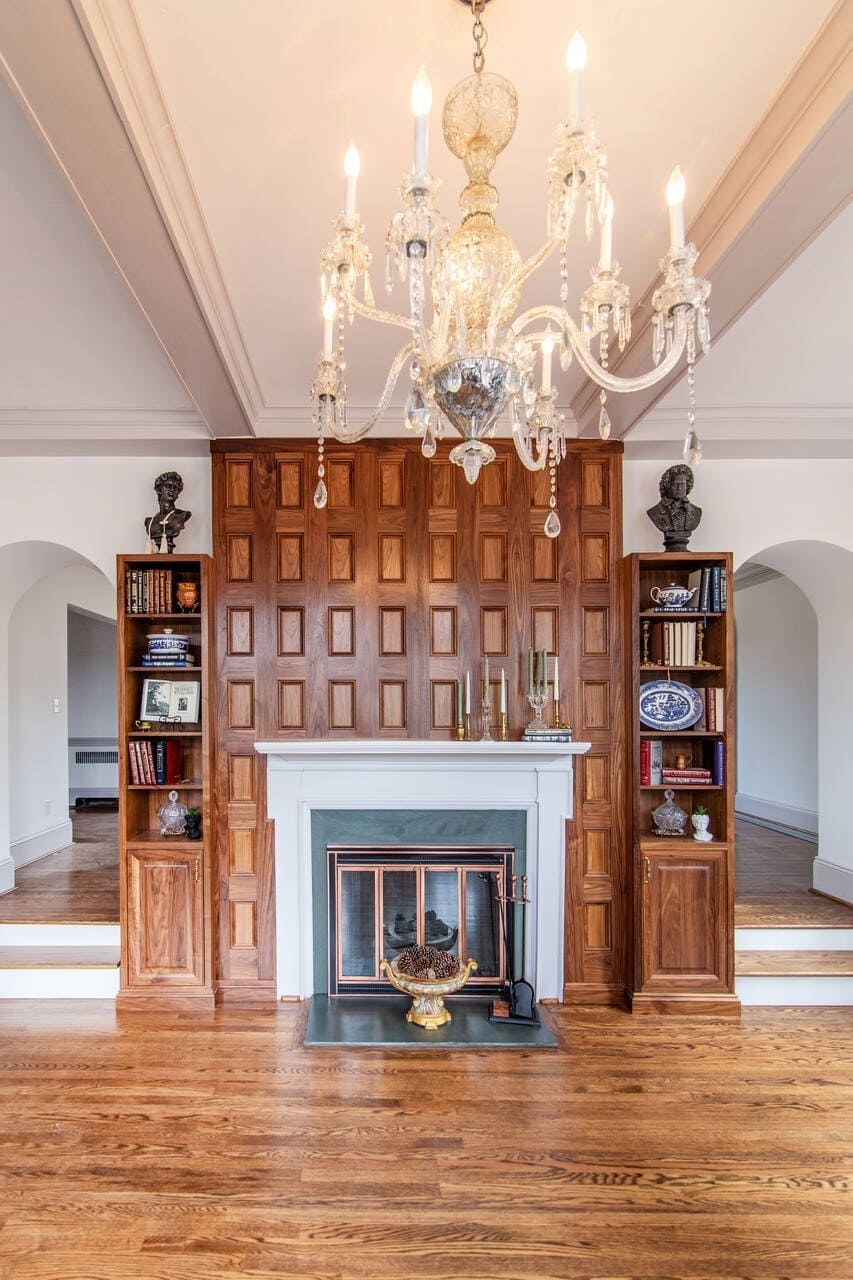 walnut fireplace with a large chandelier