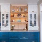 Oak, white, and blue kitchen cabinets with a pass through door