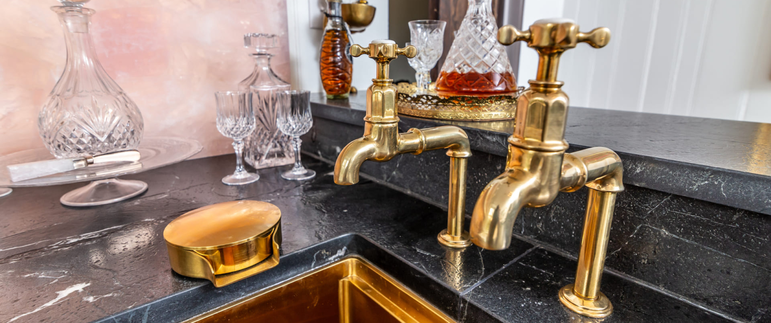 gold sink faucet on a custom bar