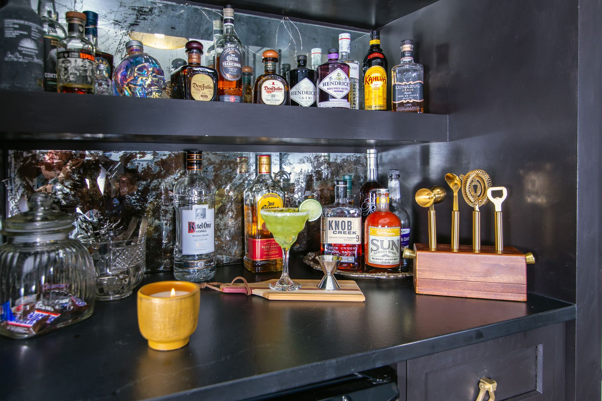 wet bar with drinks and a candle