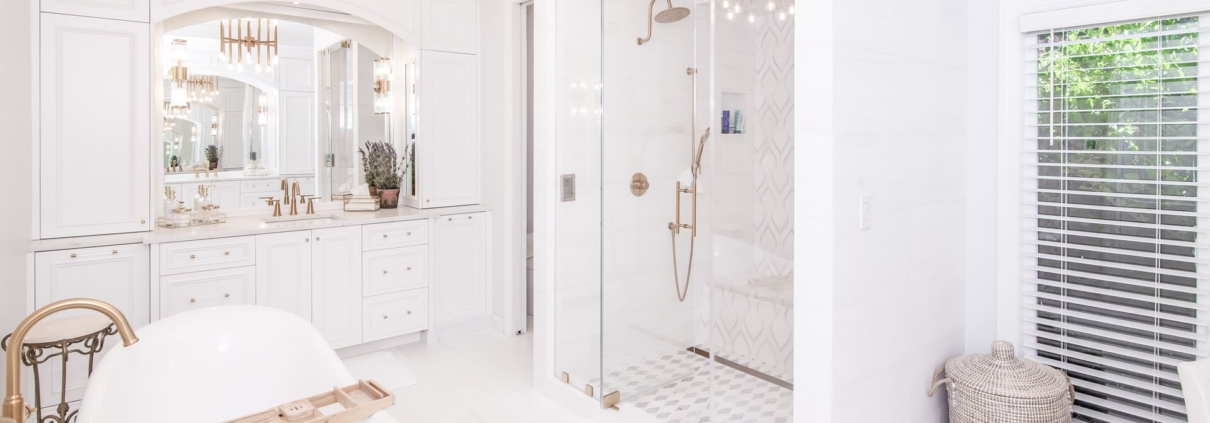 White bathroom with large light fixtures and a tub and shower
