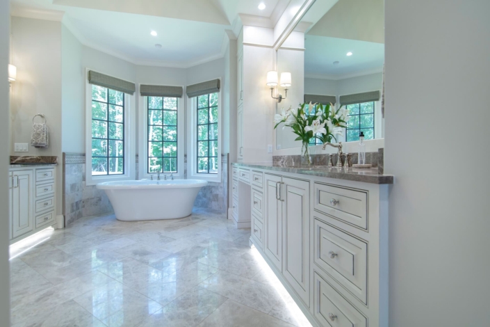 two bathroom vanities with a large tub