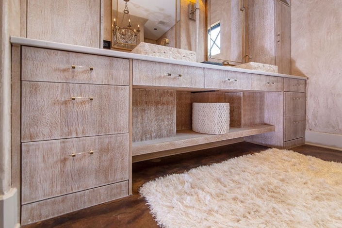 A master bathroom with cabinetry and a double vanity with a storage area