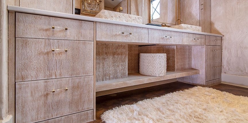 A master bathroom with cabinetry and a double vanity with a storage area